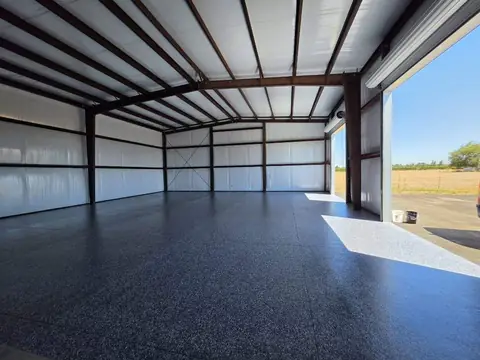 Gray flake epoxy floor in a large steel shop building